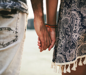 Closeup, couple and holding hands in love on beach for memory, date or holiday in relationship as...
