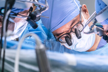 Close-up on the face of a doctor performing heart surgery on a patient in the operating room....