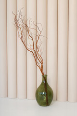 Composition bottle with twigs on a beige background