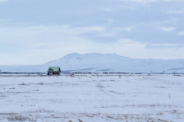Snow-covered cabin with mountain backdrop