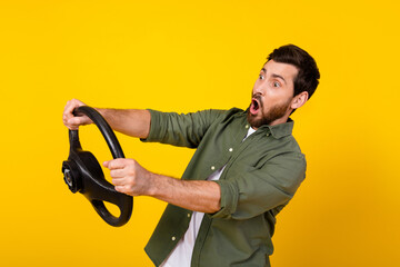 Photo of nice young man open mouth hold wheel wear shirt isolated on yellow color background