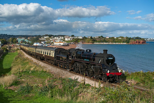 Paignton, Devon, uk. October 8th 2022. Dart valley railway in Torbay, Devon. Steam train engine pulling historic brown and beige carriages with a view across Goodrington sands towards Torquay. 