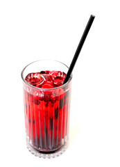 A refreshing drink with red berries in a glass with a straw