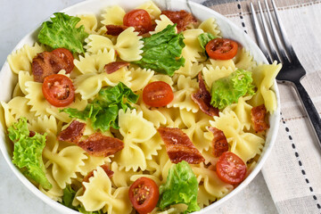 farfalle pasta with tomatoes, lettuce and bacon