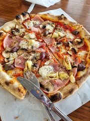 Delicious traditional Italian Capricciosa pizza simply served in a small trattoria in Trastevere, Rome, Italy