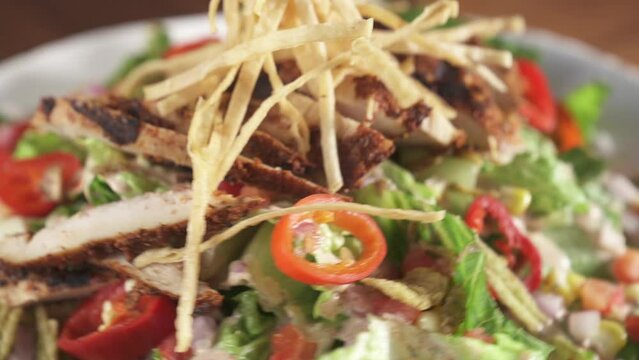 Closeup of spinning plate with fresh Caesar salad on a wooden restaurant table