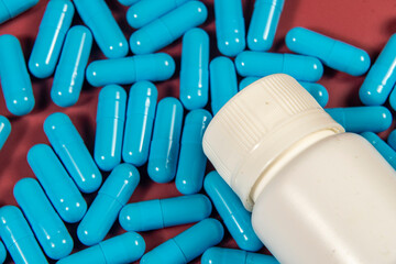 blue medicine capsules and white bottle
