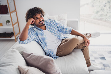 Photo of dreamy good mood man wear checkered shirt staying home relaxing couch indoors house...
