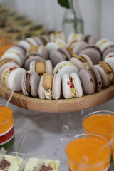 Macaroons. Candy bar on wedding banquet, birthday party, baptism close up. Pastries with cream on a golden plate. Delicious reception luxury ceremony. Table with sweets, candies, dessert. Side view