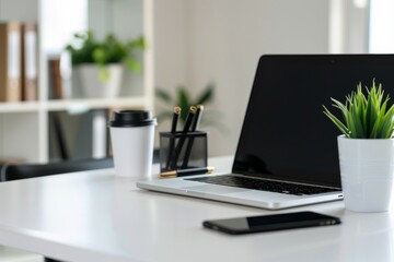 Fototapeta premium A modern office setup with a laptop, coffee cup, and office supplies on a white desk, with a significant amount of blank space above for text.