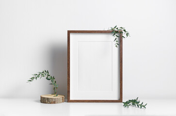 Portrait frame mockup in white minimalistic interior with botanical decorations, copy space for...