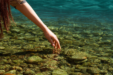 Happy. People in nature. The woman feels and touches the water. A woman's hand on the surface of water, river, sea, ocean.6