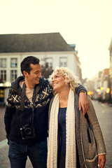 Obraz premium Couple, winter and love in city for vacation, travel and hug on holiday with smile in street. Man, woman and partnership for journey, relationship and adventure together in London with happiness