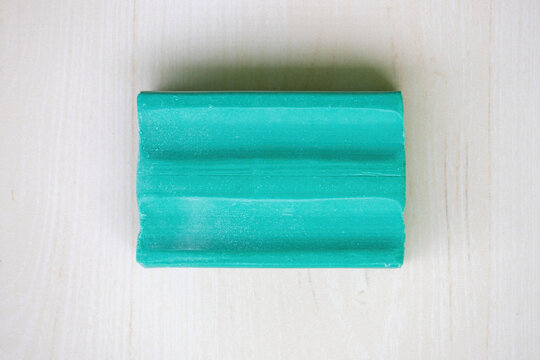 Green dishwash soap bar on wooden background. Top view.