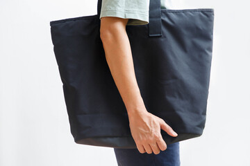 Man holding black canvas tote bag or shoulder bag