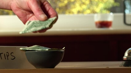 Hand leaves tips in cafe bar 