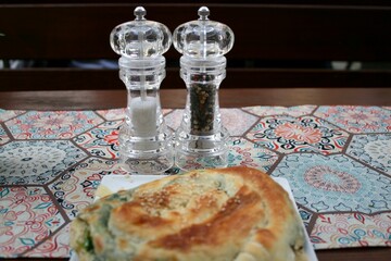 Salz- und Pfefferstreuer. Im Vordergrund „Börek“, eine türkische Spezialität aus...