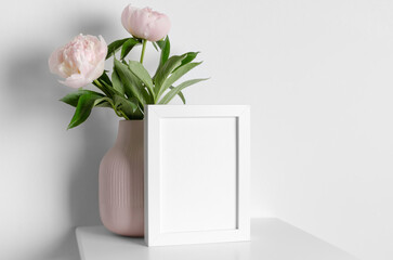 Blank white frame mockup in minimalistic interior with peony flowers, frame mock up with copy space