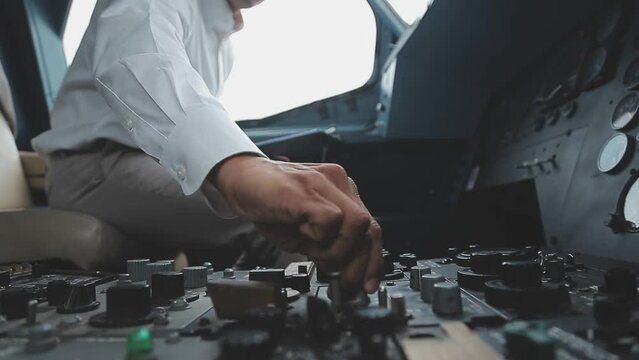 The pilot presses the power buttons on the control panel to control the aircraft in front of cockpit windshield