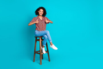 Photo of positive girl sit bar stool make thumb up sign isolated cyan color background