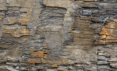 Old Aged Shabby Cliff Face And Divided By Huge Cracks And Layers