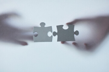 Hands, glass and puzzle together for teamwork or unity, collaboration and joint effort for project or partnership. People, pieces and engagement for union or connection, bonding and completion.