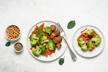 Healthy food broccoli, carrots and vegetable meatballs on a plate top view on a white background with copy space