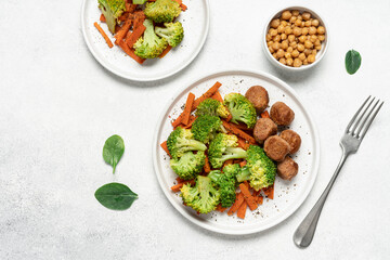 Healthy food broccoli, carrots and vegetable meatballs on a plate top view on a white background with copy space