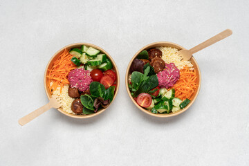 Healthy take away salad with vegan meatballs, vegetables, couscous and beetroot hummus  in...