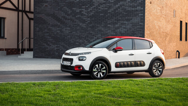 White Citroen C3 parked at the corner of modern brick building. Three quarter front view of compact hatchback in countryside at sunset. Kyiv, Ukraine - April 29 2017.