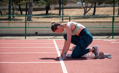 Female Athlete Preparing for a Sprint on a Track