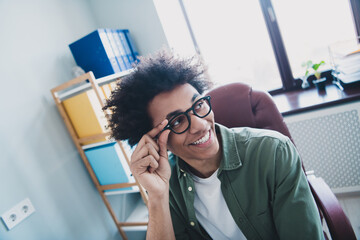 Fototapeta premium Photo of happy positive broker wear khaki shirt arm hand spectacles smiling indoors workshop workstation