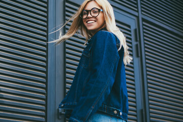 Half length portrait of happy blonde young woman in stylish eyeglasses smiling at camera.Cheerful...