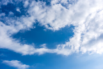Obraz premium White fluffy clouds in front of a blue sky