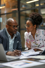 a Black business analyst discussing financial data with a colleague in a sleek office
