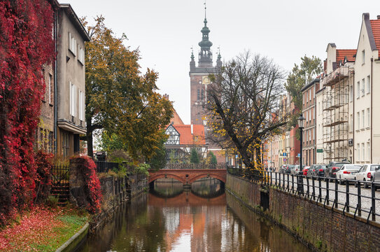 Radunia canal on a claudy autumn day. St Catherine's Church and bridge are visible in the background. Gdansk, Poland - October 22 2017.