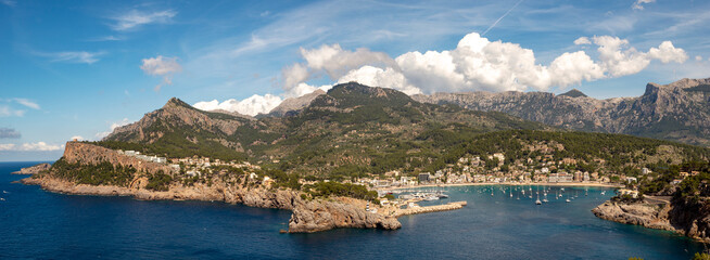 Obraz premium Panoramic view of Port de Soller coastal town surrounded by the Tramuntana mountains, in the northwest of Mallorca, Balearic Islands, Spain