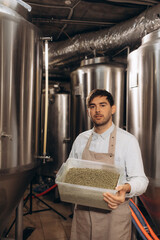 Man holding fresh green hops on blurred background, closeup.