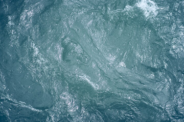 Blue water. Beautiful background with a place to copy. Close-up of raging waters. Ripples and waves...