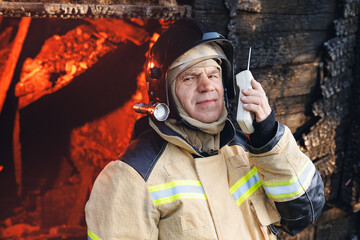 Portrait brave and strong Firefighter in burning building, house burn with open flames. Concept...