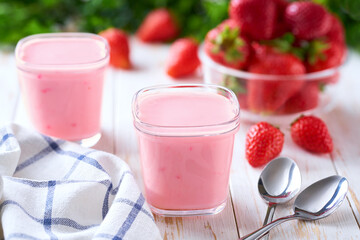 fresh natural homemade fruit yogurt in a glass jars with fresh strawberry on a light background, selective focus.