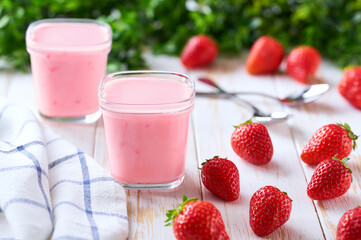 fresh natural homemade fruit yogurt in a glass jars with fresh strawberry on a light background, selective focus.