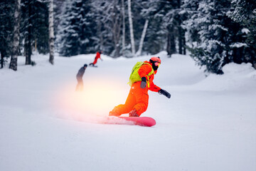 Freeride snowboarding in Sheregesh Ski Resort on background snowy forest. Man snowboarder rides...