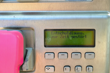 Telefonzelle, alte rote Telefonzelle, altes Münztelefon auf einer Edelstahlsäule, mit rosa...