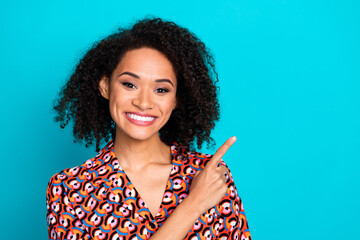 Photo of shiny attractive lady dressed print shirt pointing finger empty space isolated turquoise...