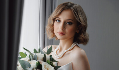 Portrait of happy elegant young woman in modern bridal look with classic hairstyle and makeup hold white rose bouquet