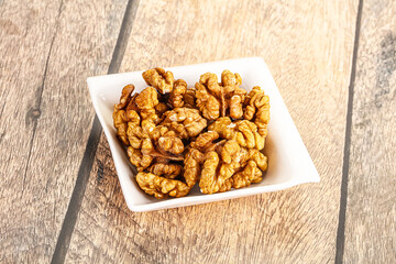 Cracked unshelled walnut in the bowl