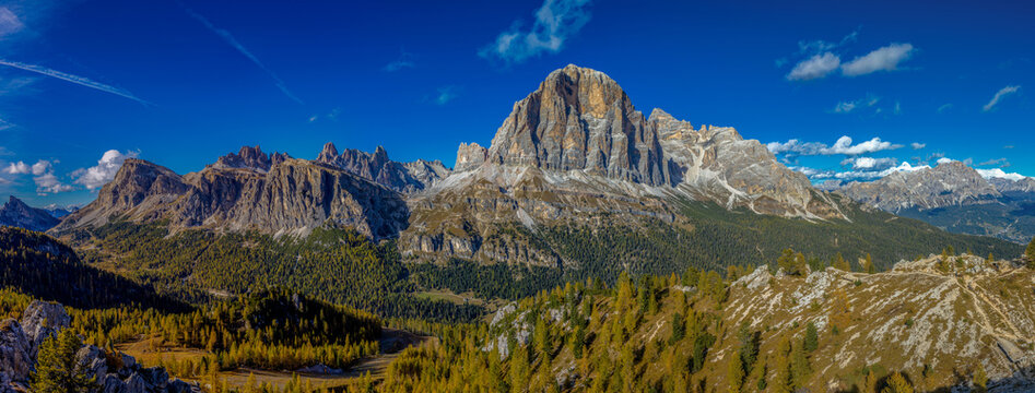 Panorama of the Dolomites mountains on a sunny day, blue sky with soe clouds. Beautiful mountians of Alpi Dolomiti in Italy, South Tirol alpine range in autumn