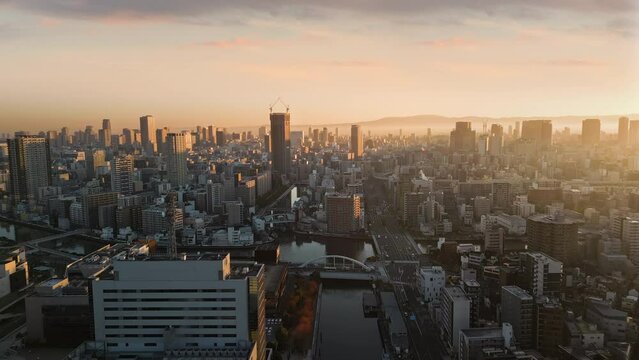 osaka city downtown aerial view drone at sunrise modern high rise office buildings,sunlight lighting up the town