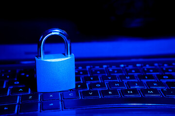 Computer security concept with a closed padlock on the keyboard.padlock on top of a laptop keyboard.Selective focus,closeup.Toned.

